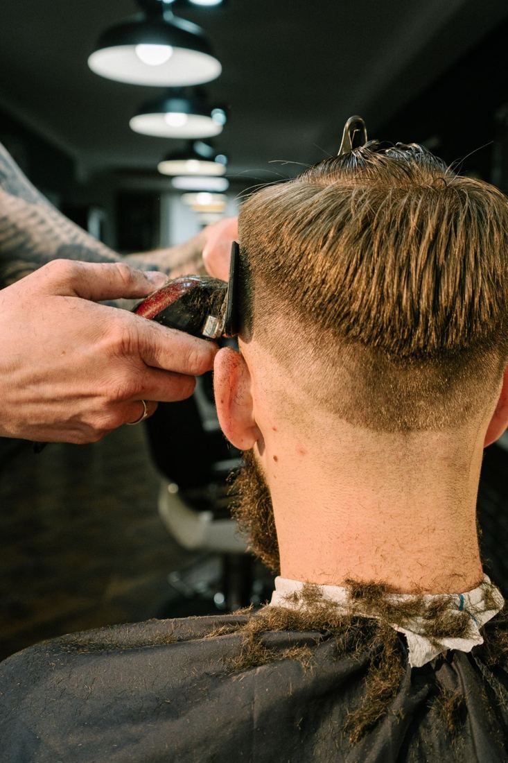 Barbeiro cortando cabelo com tesoura